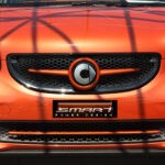 Front grille SLS in color lava orange metallic with original Smart emblem for Smart Fortwo 453